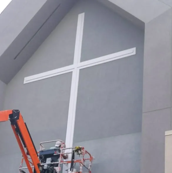 Steep-slope commercial gable wall with lift equipment on site